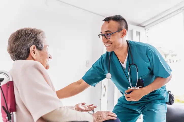 A male nurse assists an elderly woman in a wheelchair, showcasing skilled nursing care in Shreveport, LA