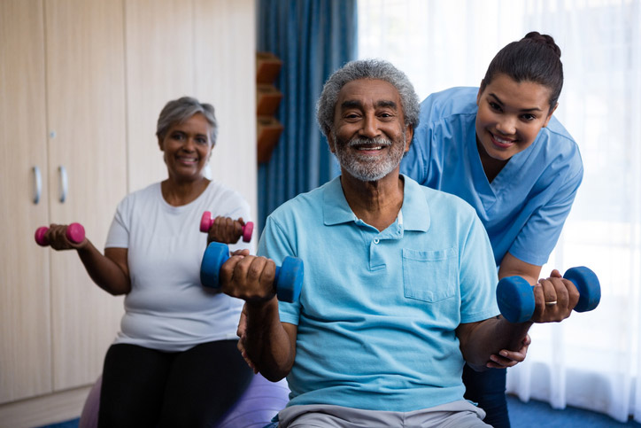 Two seniors lifting weights during outpatient therapy session at the Guest House Skilled Nursing & Rehabilitation in Shreveport, LA